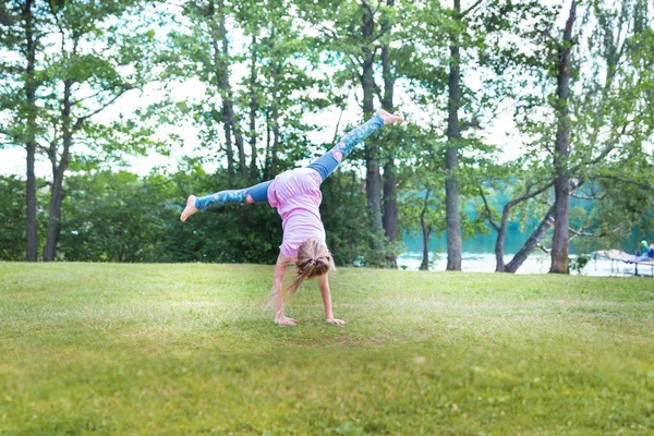 Gadis Pirang Kecil Mengubah Cartwhell Luar Ruangan Lapangan — Stok Foto