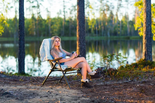 紅茶のカップが付いている湖の近くでキャンプの若いブロンドの女性 — ストック写真