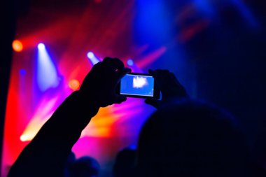 Silüetler kalabalık parti konser müziği cep telefonu ile fotoğraf video çekmek Adam