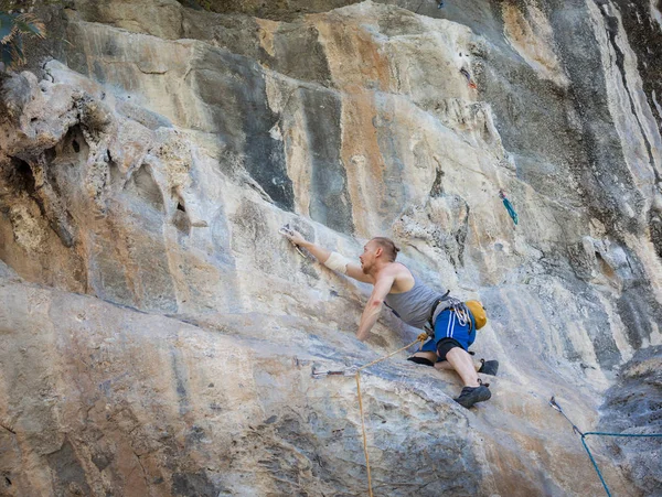 Young man rock climbing on karst limestone white mountain in Thailand — 스톡 사진