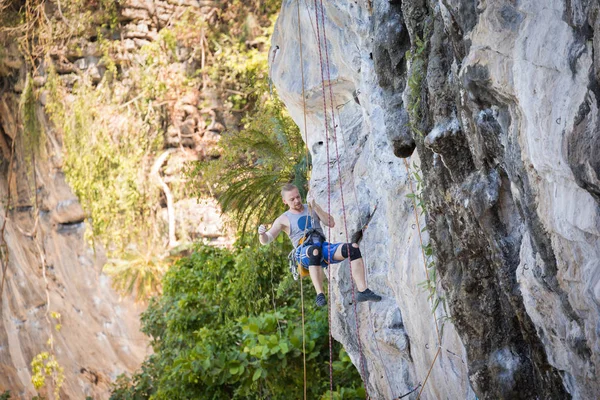 Young man rock climbing on karst limestone white mountain in Thailand — 스톡 사진