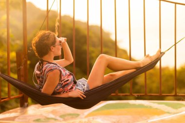 Tropikal egzotik hamak günbatımı ışıklar genç ince kadın