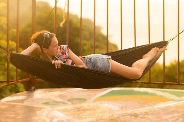 Young slim woman in tropical exotic hammock sunset lights — Stock Photo, Image