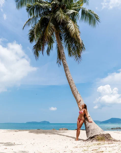 Ung smal kvinna nära handflatan på vit tropisk strand — Stockfoto