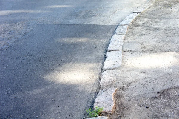 Σκυρόδεμα γκρι άσφαλτο στο δρόμο, πεζοδρόμιο, στα σύνορα των δρόμων φτιαγμένο από τούβλα — Φωτογραφία Αρχείου