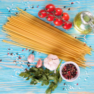 Mavi ahşap zemin üzerine İtalyan makarna için malzemeler.