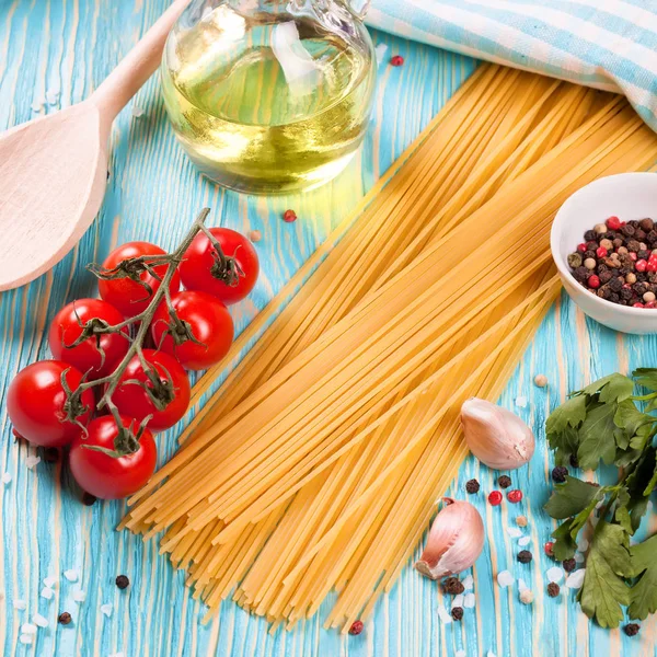 Mavi ahşap zemin üzerine İtalyan makarna için malzemeler.
