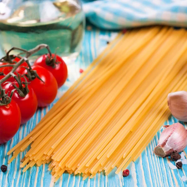 Mavi ahşap zemin üzerine İtalyan makarna için malzemeler.