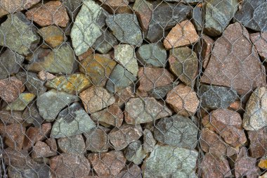 Gabion, doku, arka plan. Doğal kayalardan ve metal çitlerden yapılmış duvar..