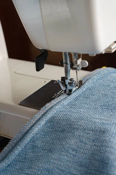 Šicí stroj. proces šití ozdobné šňůry z modré tkaniny. — Stock fotografie