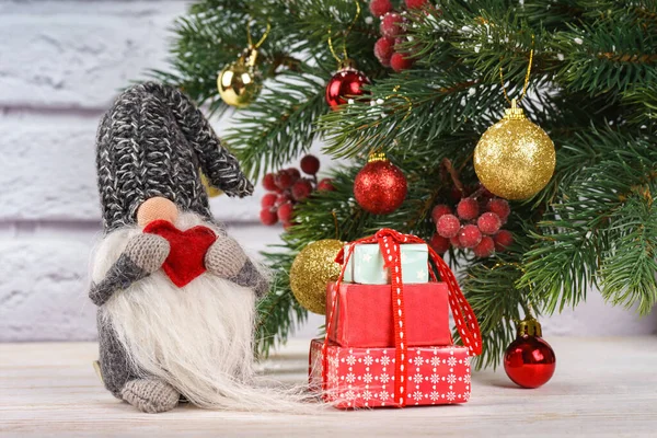 Ano Novo brinquedo gnomo com coração vermelho no fundo da árvore de Natal — Fotografia de Stock