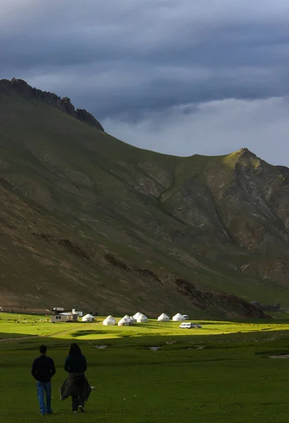Tash Rabat yurts kampı edilişi, öğleden sonra geç saatlerde, ışık ve gölge görünümünü. Arka plan, yeşil otlaklar yüksek dağın.