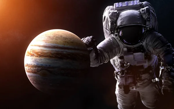Jupiter sur un fond flou avec un astronaute géant. Des éléments de l'image sont fournis par la NASA — Photo