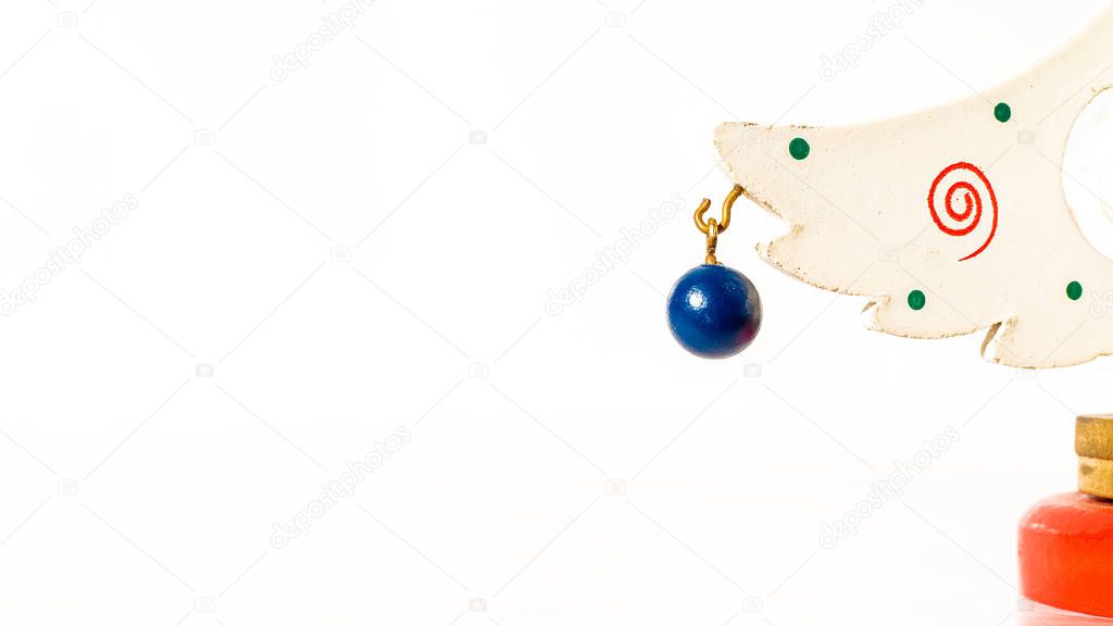 Christmas white ticket decorated with a wooden blue ball hanging on a branch of a wooden toy Christmas tree