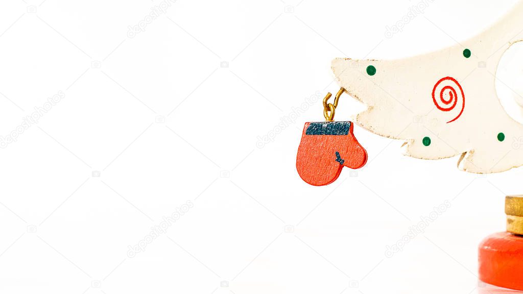 Christmas white ticket decorated with a wooden red glove hanging on a branch of a wooden toy Christmas tree