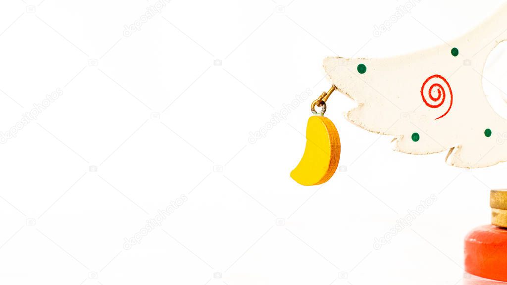 Christmas white ticket decorated with a wooden yellow moon hanging on a branch of a wooden toy Christmas tree