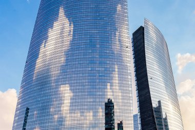 Bölme, iki bölümünden bölünmüş silindirik camlı yapı standları Milan gökyüzünde bulutlar ve başka konstrüksiyonlar yansıtan