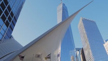 New York Ocak 2020 - Oculus binasının beyaz yapısının ön plandaki gölgede kalan kanadı. Arkaplanda Dünya Ticaret Merkezi Meydanı 'nın gökdelenleri var.
