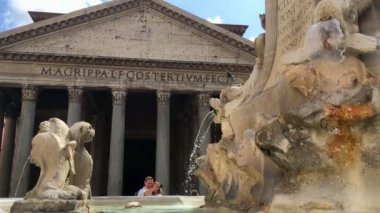 Roma - Eylül 2019 - Bir çift Roma 'nın tarihi merkezinde Pantheon' un önünde selfie çekerken bir güvercin fıskiyenin ön tarafındaki bir noktasından diğerine uçuyor.