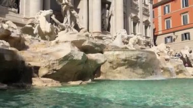 Roma 'nın tarihi merkezinde Trevi Çeşmesi' ni oluşturan mermer ve travertin taşların üzerinde duran insan ve atları tasvir eden muhteşem heykeller, kameranın dikey hareketi