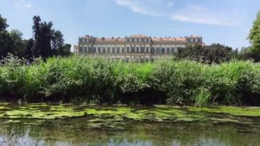 Monza, Ağustos 2019 - Monza Kraliyet Sarayı 'nın göletli parkı, bir yusufçuk ve dinlenen insanlar. Kamerayı sağa çevir.