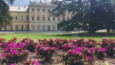 Como, Temmuz 2019 - Villa Olmo Botanik Bahçesi ve turistler yaz günü çimenlikte piknik yapıyorlar.