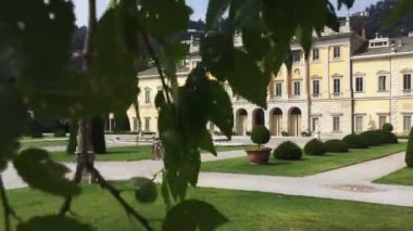 Como, Temmuz 2019 - Güneşli bir günde turistlerle birlikte ağaçların arasında karaağaç konteynırı görüntüsü. Kamera aşağı eğik