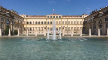 Monza, Ağustos 2019 - Monza kraliyet villasının girişi çeşmeli, tarihi bina ve İtalyan bayrağı ile. Kamera doldur.