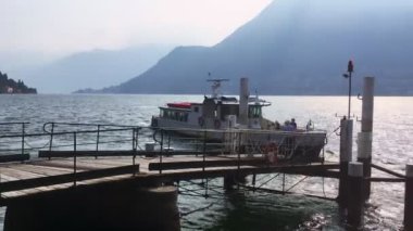 Cernobbio, Temmuz 2019 Como Gölü 'ndeki istasyona feribot geliyor ve turistler yelken açmak için bekliyor. Kamerayı sola çevir