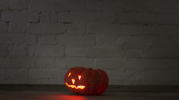 Halloween Pumpkin Carved Scary Face Rotates Brick Wall Night Glares — Stock Video