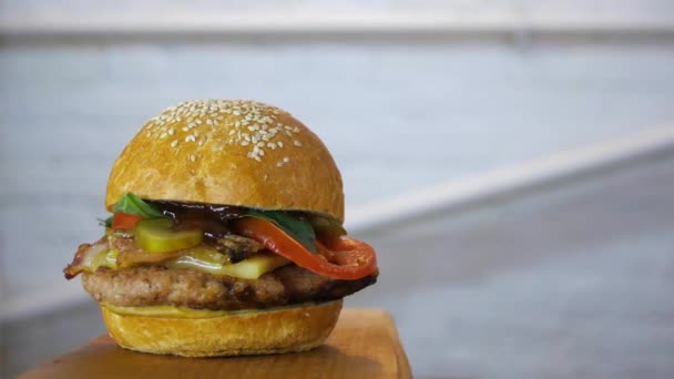 木の板にできたてのおいしいハンバーガーの回転 クローズ アップ — ストック動画