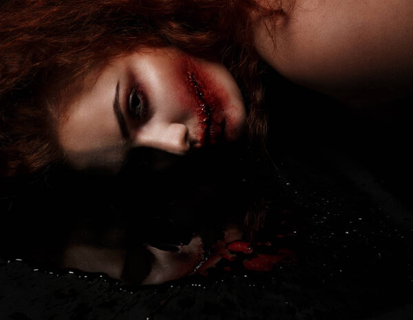 dead ginger girl on the floor with a skull reflected in a pool of blood. Halloween hard concept