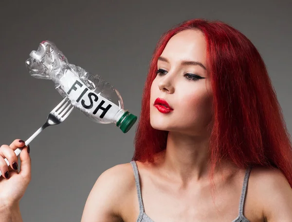 Yeryüzünün plastik kirliliği. Plastik şişede Balık Kelimesi yiyen kız. Ekolojik sorun kavramı.