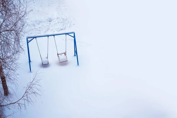 雪覆盖了冬季操场 在公园荡秋千 — 图库照片
