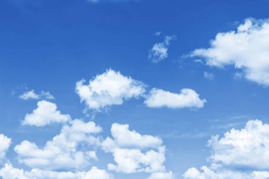 Arka plan bulanık. Mavi gökyüzü ve beyaz kabarık bulutlar.