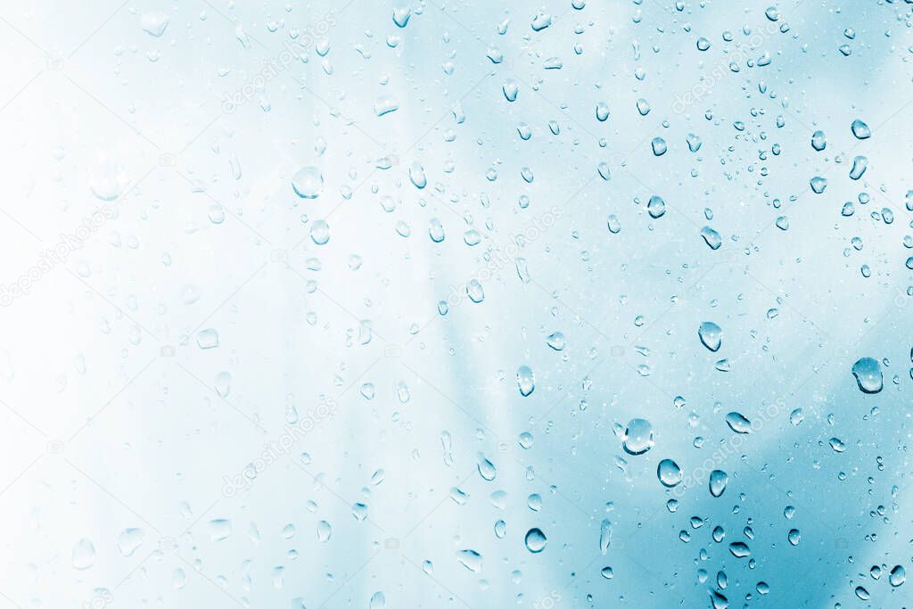 Natural pattern. Raindrops on window glasses surface with cloudy background .