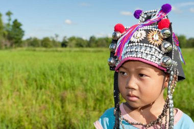 Asyalı çocuk etnik Akha, çeltik üzerinde geleneksel giyim