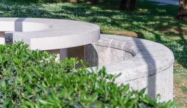 Yaz parkında beyaz taş bir bank.