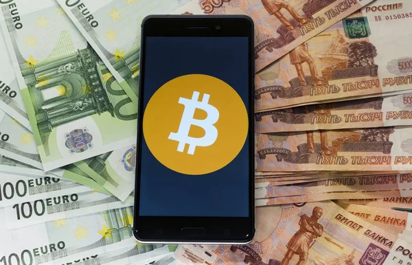 Euro ve ruussia para arka planda bir bitcoin logosu ile Telefon