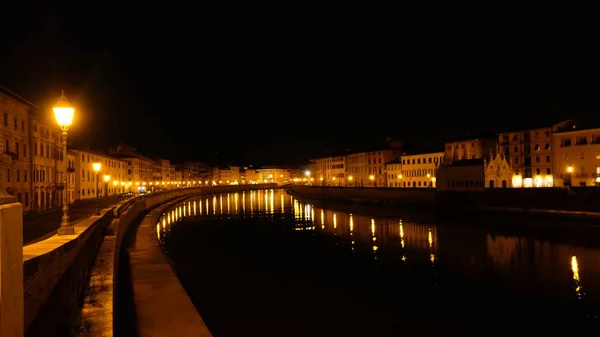 Night lights reflection by the river in Pisa