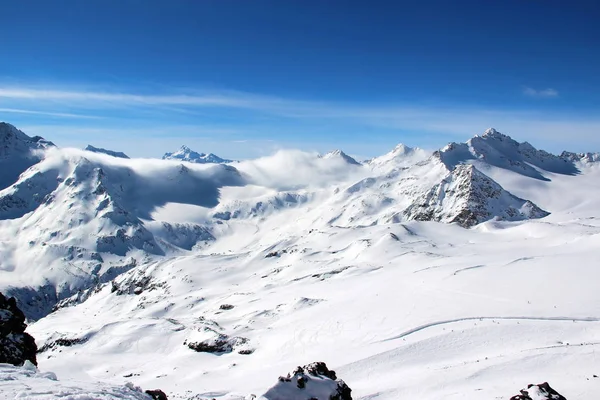 Montañas nevadas en las nubes cielo azul Cáucaso Elbrus —  Fotos de Stock