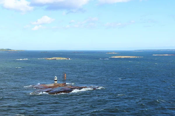 mavi gökyüzü beyaz bulutlar denizinde küçük taş Adası