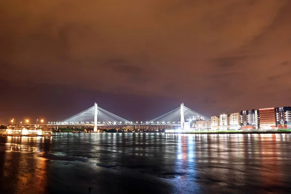 夜晚，河上有一座巨大的斜拉桥，灯火通明 — 图库照片