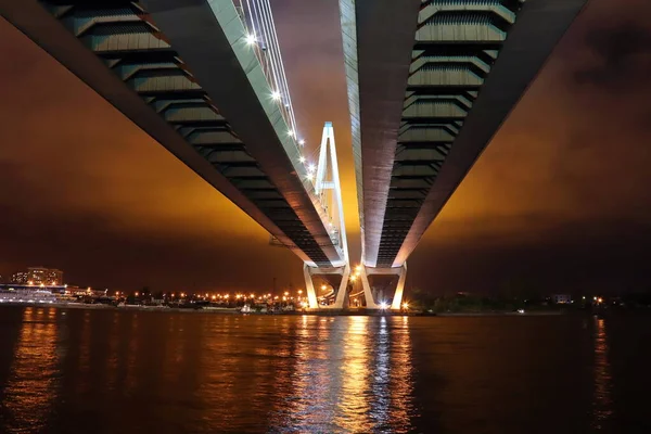夜晚，河上有一座巨大的斜拉桥，灯火通明 — 图库照片