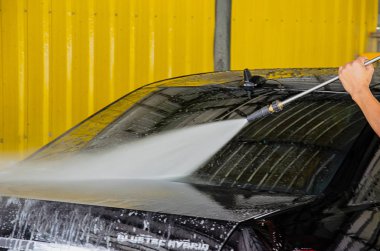 Erkekler araba yıkama yüksek basınçlı su ile Çalıştır..