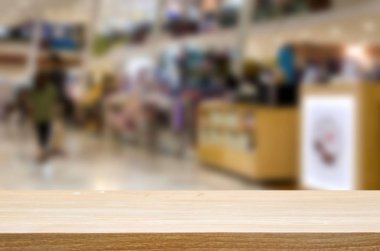 Ahşap masa üstü ve soyut alışveriş merkezi mağaza iç için arka plan bulanıklık. kullanılması, görüntülenmek veya ürün montaj.