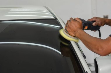 Man working for polishing, coating cars. clipart