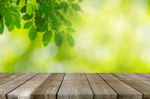 Holz Tischplatte Und Abstrakte Unschärfe Grüne Blätter Hintergrund — Stockfoto