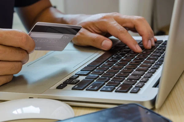 Çevrimiçi Alışveriş Kredi kartıyla Dizüstü bilgisayar kullanıyor. Elleri kredi kartı tutuyor..