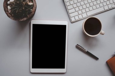 Klavyesi, bilgisayarı, tableti, kalemi, kahvesi ve kaktüsü olan bir ofis masası. İş ve finans kavramı